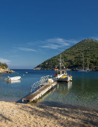 Sailboats moored on sea against sky