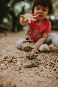 Child playing with sand and stones outdoors