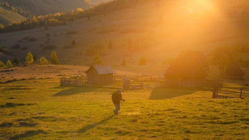 Man walking on field during sunset