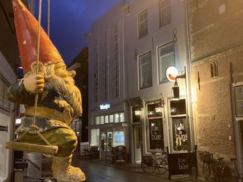 Low angle view of statue against building at night