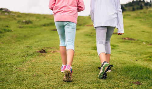 Low section of woman walking on field