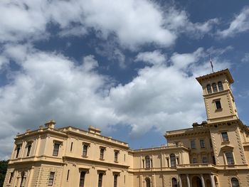 Low angle view of buildings against cloudy sky