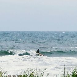 Man surfing in sea against clear sky