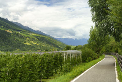 Road leading towards mountains against sky