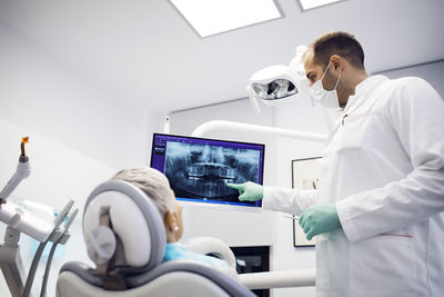 Dentist explaining x-ray to female patient at clinic