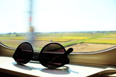 Close-up of sunglasses on road against clear sky