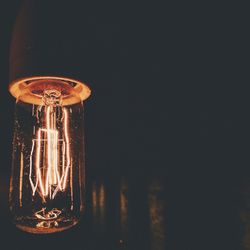 Close-up of illuminated light bulb in dark room