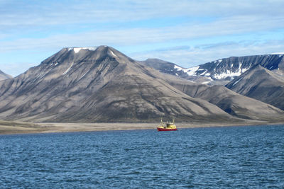 Scenic view of sea and mountains against sky