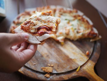 Cropped hand holding pizza