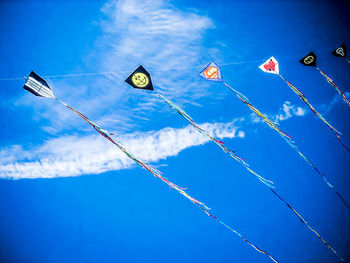 Low angle view of flags against blue sky