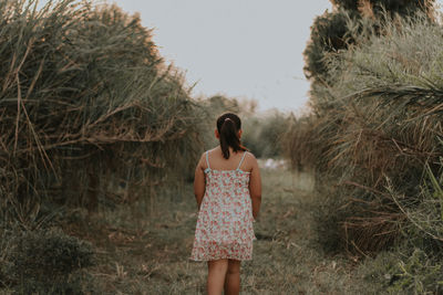 Full length of woman standing on land against sky