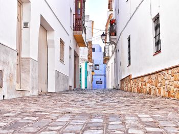 Walkway amidst buildings against sky