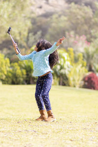 Rear view of woman with arms raised