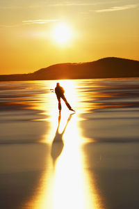 Woman long-distance skating at sunset