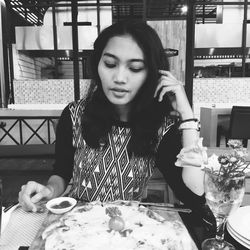 Portrait of young woman sitting at restaurant