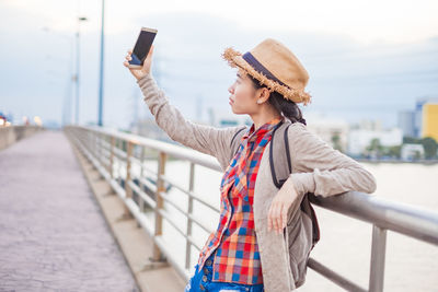 Full length of young woman using mobile phone