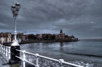 View of buildings in city against cloudy sky