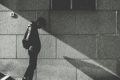 Side view of woman walking on sidewalk