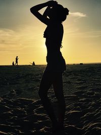 Silhouette people at beach during sunset