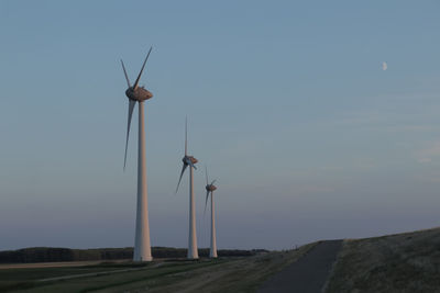 Scenic view of wind turbines against sky