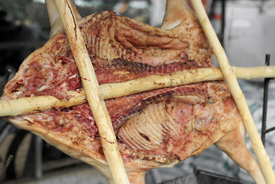 Barbecued suckling pig on a grill with wooden coal. whole roasted piglet body turning on grill.