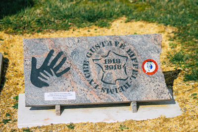 High angle view of arrow sign on rock