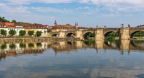 Arch bridge over river against sky