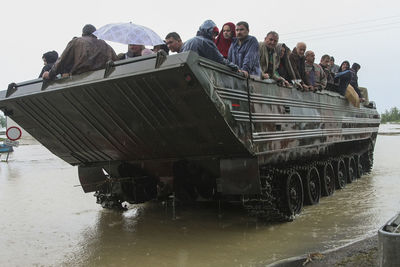 People on boat in sea against sky