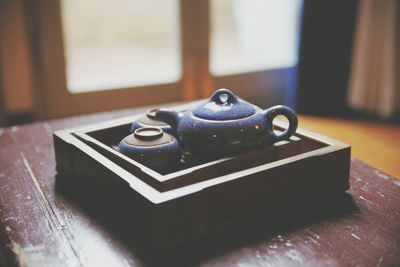 Teapot with cup on wooden table