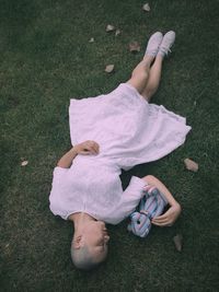 High angle view of girl lying on grassy field