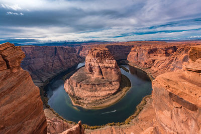 Scenic view of rock formations against cloudy sky