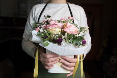 Midsection of bride holding bouquet