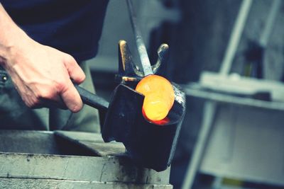 Man working molding hot metal in workshop