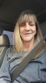 Portrait of smiling young woman sitting in car