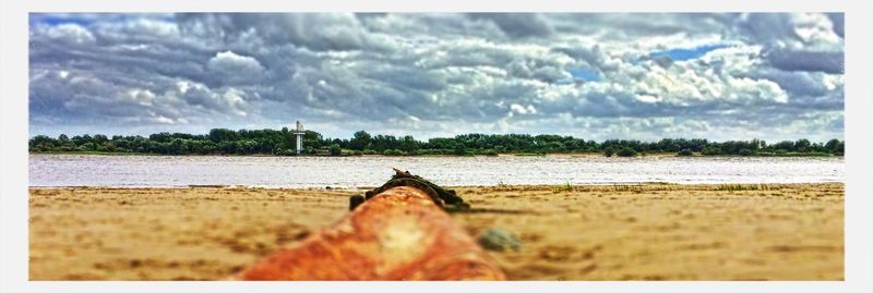 Scenic view of lake against cloudy sky