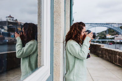 Woman photographing with mobile phone in city