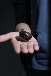 Midsection of person holding bracelet