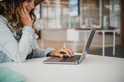 Midsection of woman using laptop on table