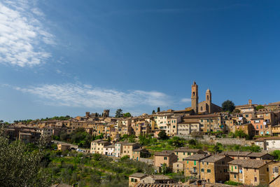 Buildings in city against blue sky