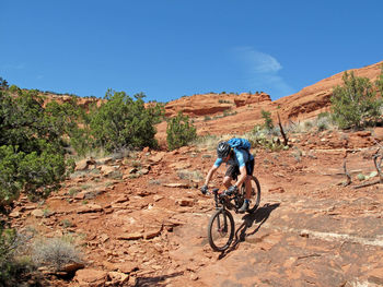 Woman riding bicycle on mountain road