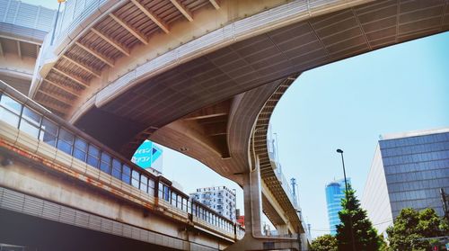 Low angle view of bridge and buildings against clear sky