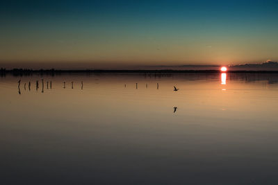 Scenic view of calm lake at sunset