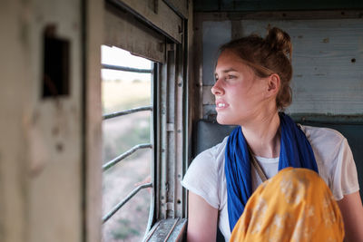 Woman looking through window of train