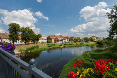 Scenic view of lake by buildings against sky