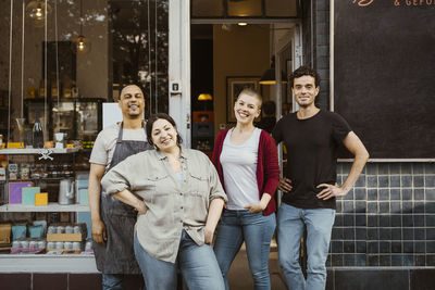 Male and female business colleagues standing outside deli