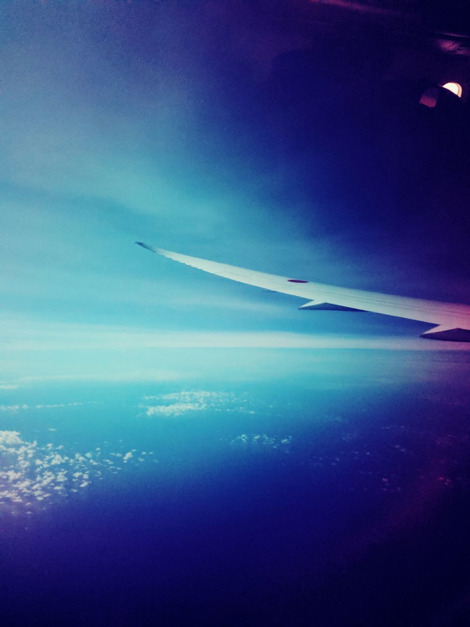 AIRPLANE FLYING OVER SEA AGAINST BLUE SKY