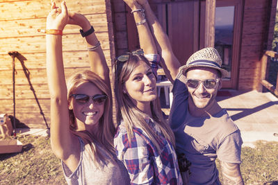 Portrait of smiling friends sitting on swing