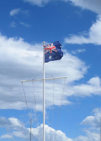 Low angle view of australian flag on pole against sky