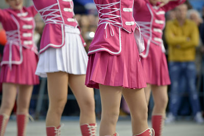 Low section of children on pink outdoors