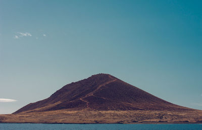 Scenic view of mountain against blue sky